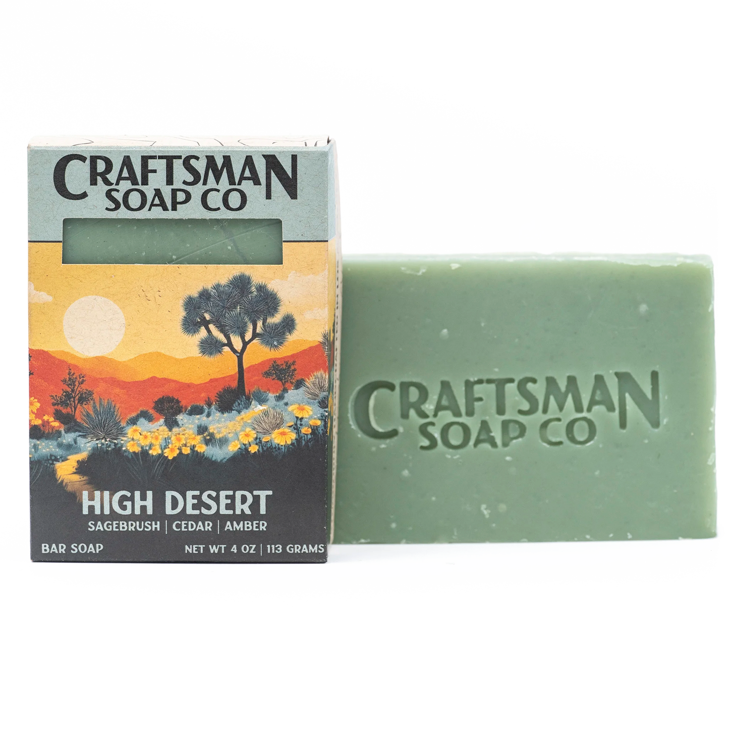 High Desert natural handmade soap bar by Craftsman Soap Co, teal with brand stamp, beside Joshua Tree sunrise desert gift box, essential oils, cold process