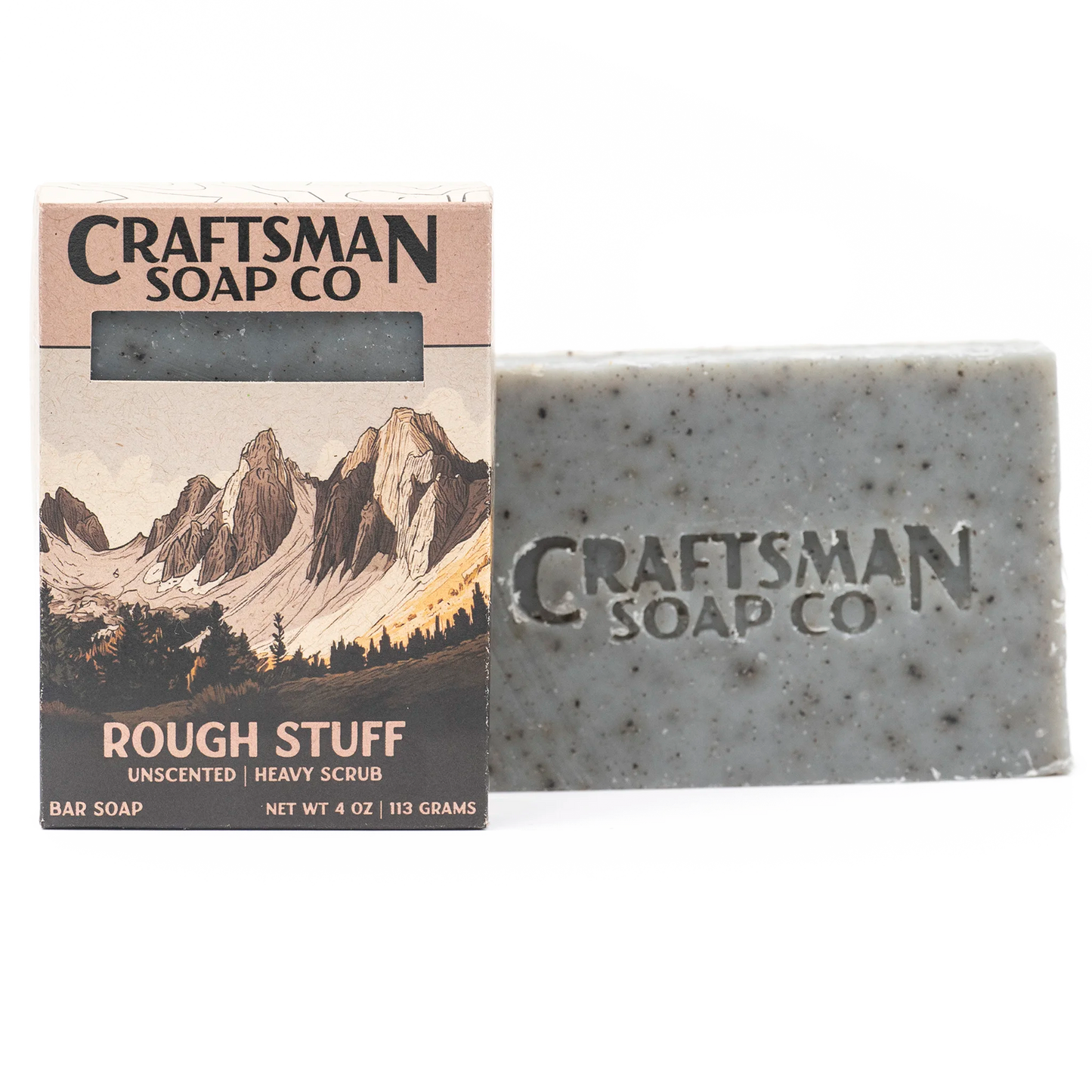 Rough Stuff handmade exfoliating soap bar by Craftsman Soap Co, grey with brown flecks, beside alpine mountain gift box, pumice and coffee grounds, unscented